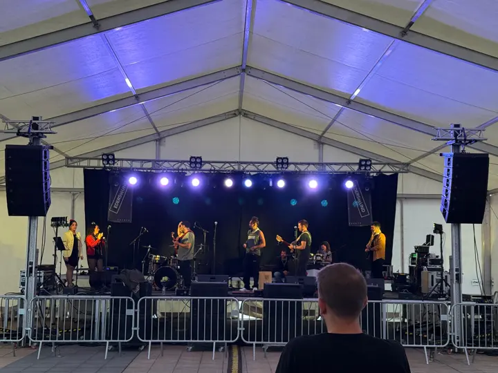 Escenario en una carpa con iluminación azul y equipo de sonido